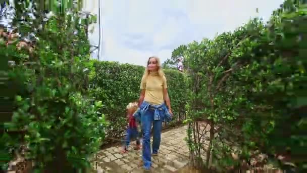 Мать с дочерью отдыхают в ботаническом саду — стоковое видео