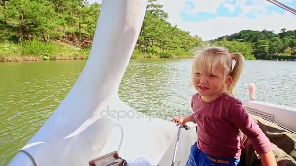 Meisje op zwaan boot in lake zwemmen — Stockvideo