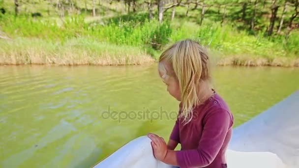 Mädchen schwimmt auf Schwanenboot im See — Stockvideo