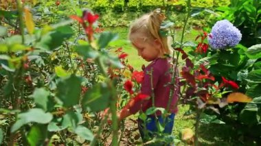tropikal park çiçeklerle oynayan kız
