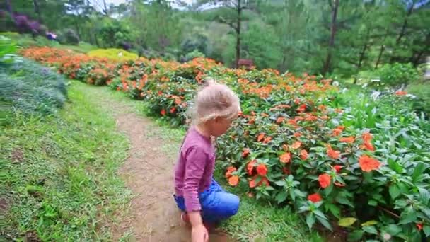 Little girl smells tropical flowers — Stock Video