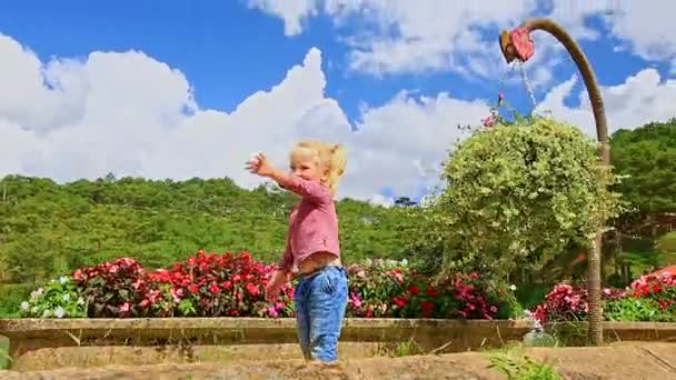 Malá holčička hraje v tropickém parku — Stock video