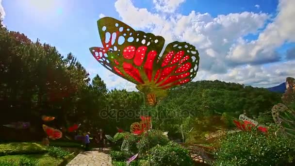 Loopbrug tussen tropische planten en kunstmatige vlinders — Stockvideo