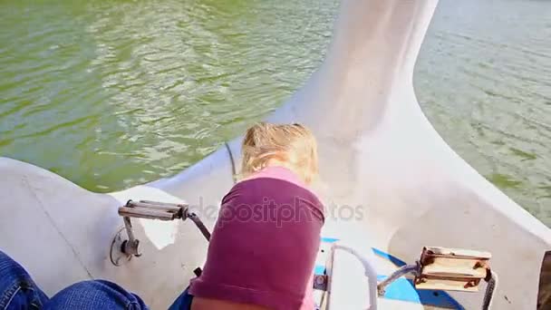 Meisje op zwaan boot in lake zwemmen — Stockvideo