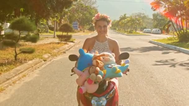 Chica velocidades en ciclomotor con juguetes con lo largo de la carretera — Vídeo de stock