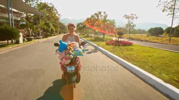 Mädchen rast auf Moped mit Spielzeug auf Straße — Stockvideo