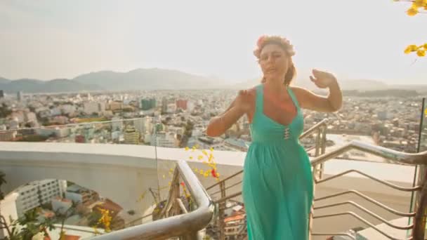 Girl dances on hotel stairs against city — Stock Video