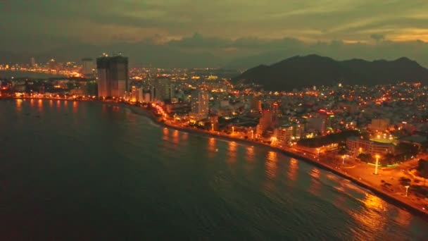 Night city across ocean bay — Stock Video
