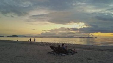 Çift ve köpeklerle insanlar denize yakın dinlenme