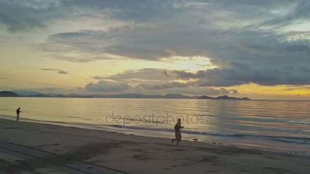 Hombre trota a lo largo de la playa de arena — Vídeo de stock