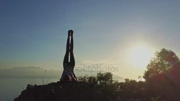 Mädchen macht Yoga auf großer Klippe — Stockvideo