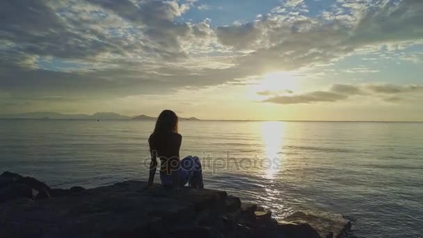 Meisje zit op het strand en geniet van zeegezicht — Stockvideo
