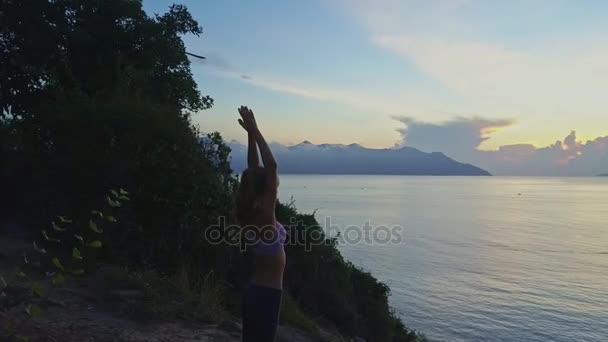 Flicka gör yoga på stora klippan — Stockvideo