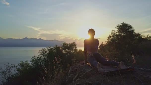 Girl doing yoga on large cliff — Stock Video