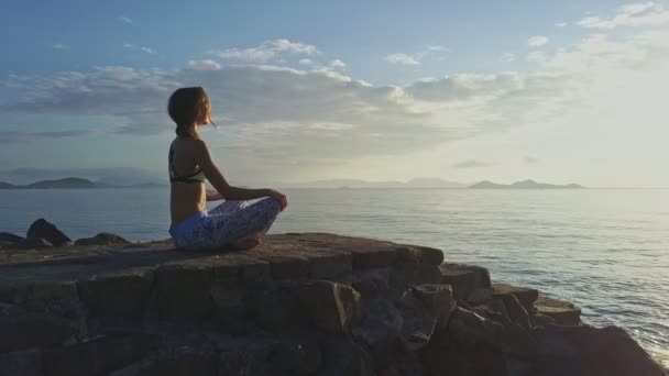 Chica hace yoga en la playa rocosa — Vídeos de Stock