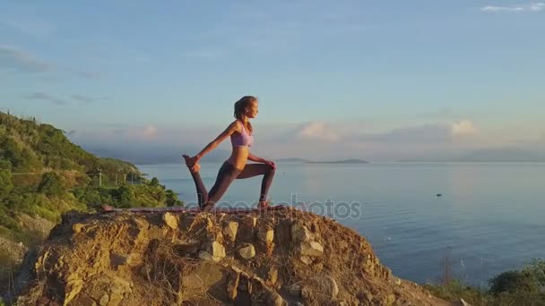 Flicka gör yoga på stora klippan — Stockvideo