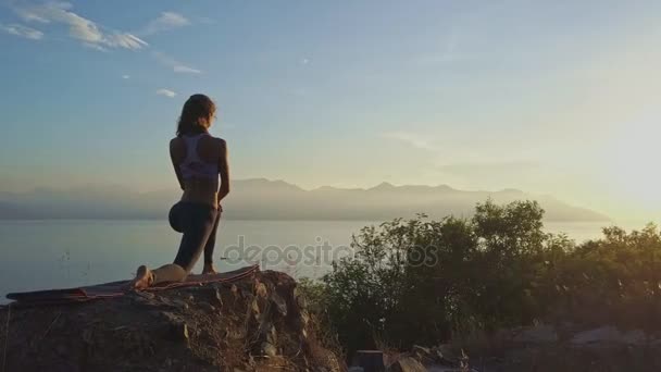 Girl doing yoga on large cliff — Stock Video