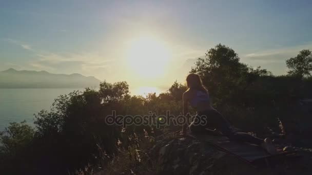 Mädchen macht Yoga auf großer Klippe — Stockvideo