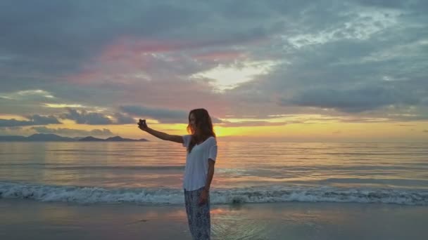 Menina faz selfie na praia de areia — Vídeo de Stock