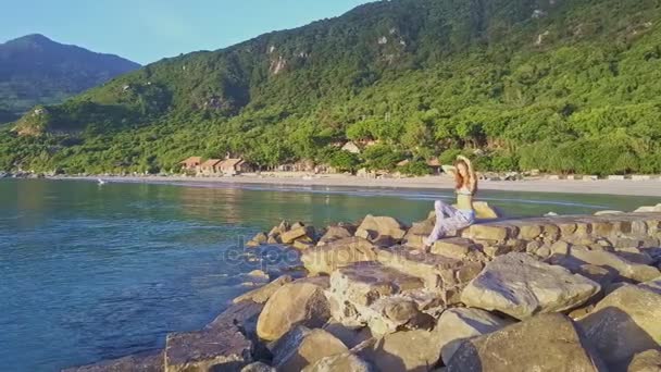 Chica se sienta en la playa y disfruta del paisaje marino — Vídeos de Stock
