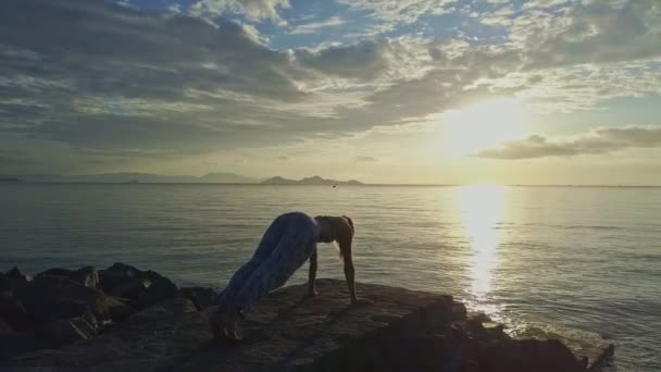 Fille fait du yoga sur la plage rocheuse — Video