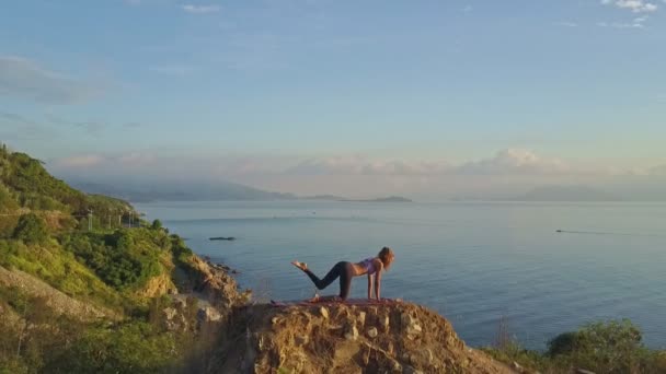 Mädchen macht Yoga auf großer Klippe — Stockvideo