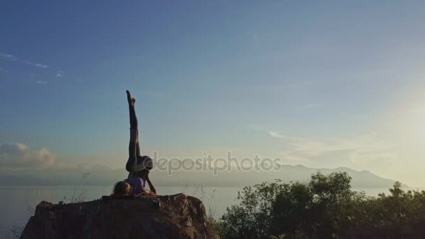 Girl doing yoga on large cliff — Stock Video