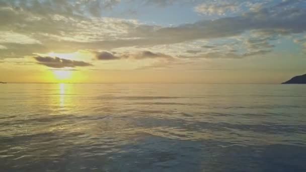 Морской пейзаж сливается с живописным золотым восходом солнца — стоковое видео