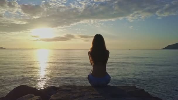 Chica se sienta en la playa y disfruta del paisaje marino — Vídeo de stock