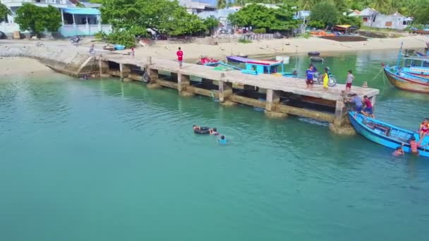 Kinder schwimmen an Seebrücke im azurblauen Meer — Stockvideo