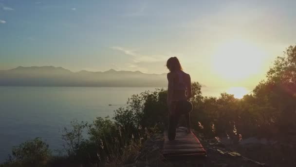 Girl doing yoga on large cliff — Stock Video