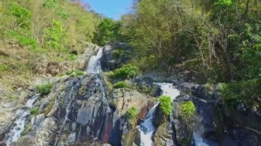 şelale sarp kayalık yamaçlar arasında