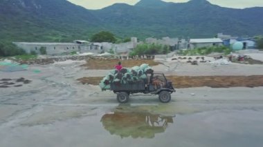 Araba plaj boyunca sürüş yosun çuval ile