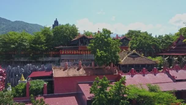 Boeddhistische tempel complex onder tropische planten — Stockvideo