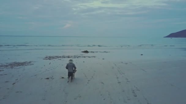 Muž shromažďování řasy od pobřeží oceánu do košíku — Stock video