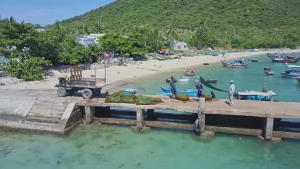 Människor som arbetar på pier nära båtar i havet — Stockvideo