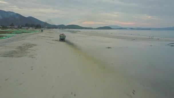 Car with algae sacks driving along beach — Stock Video