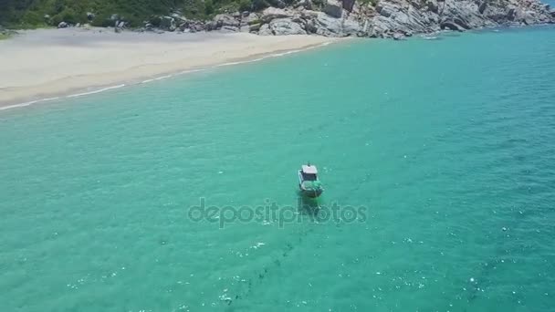 Лодка плывет по океану на песчаном пляже — стоковое видео