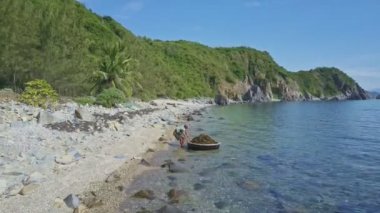 adam tekne ith alg sahile çeker.