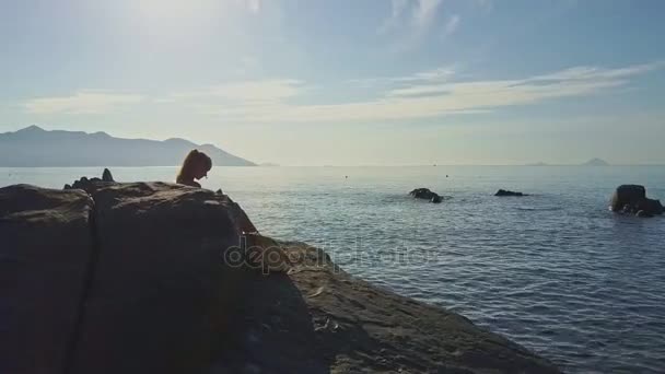 Flickan sitter på rock och gör selfie — Stockvideo