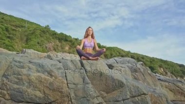 kayalık okyanus kıyısında yoga yaparken kız