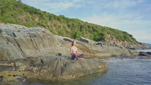 Holka dělá jógu na pobřeží skalnaté oceánu — Stock video