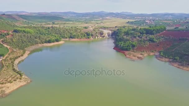 Cachoeira flui para o rio contra a paisagem — Vídeo de Stock