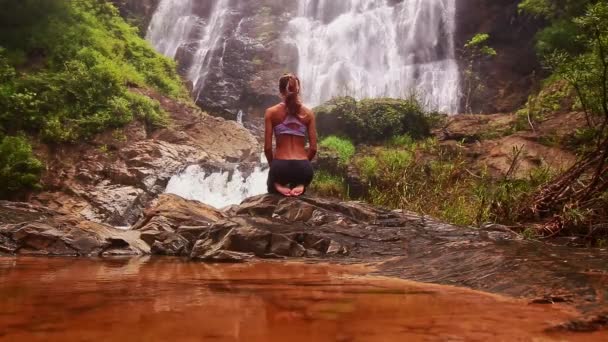 Frau macht Yoga in der Nähe des Wasserfalls — Stockvideo