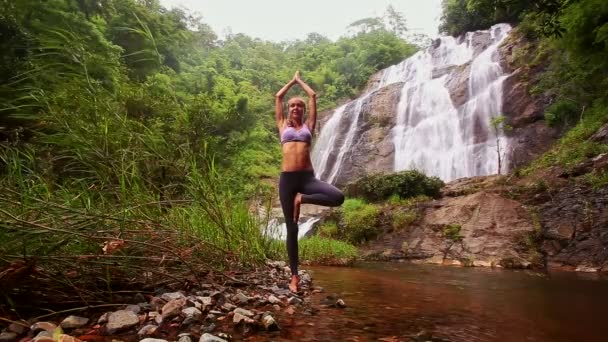 Frau macht Yoga in der Nähe des Wasserfalls — Stockvideo