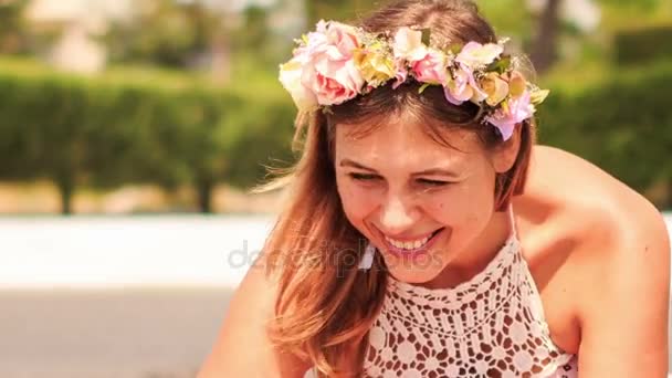 Женщина в искусственных цветочных гирляндах улыбается — стоковое видео