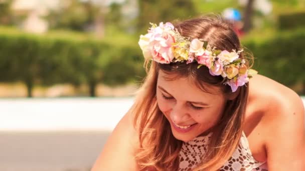 Mujer en guirnalda de flores artificiales sonríe — Vídeos de Stock