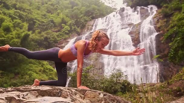 Mujer haciendo yoga cerca de la cascada — Vídeo de stock
