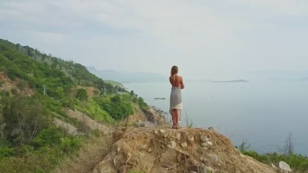 Chica disfrutando del océano y paisaje desde la cima de la colina — Vídeos de Stock