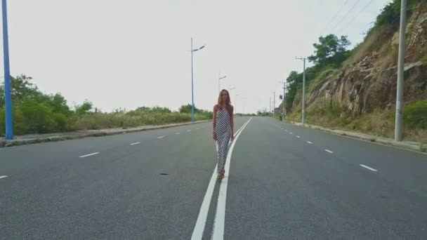 Fille marche le long de l'autoroute vide — Video